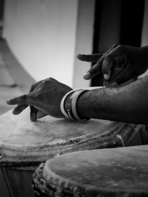 Mains du percussionniste Claude Saturne sur le tambour lors d'un atelier Expression Primitive