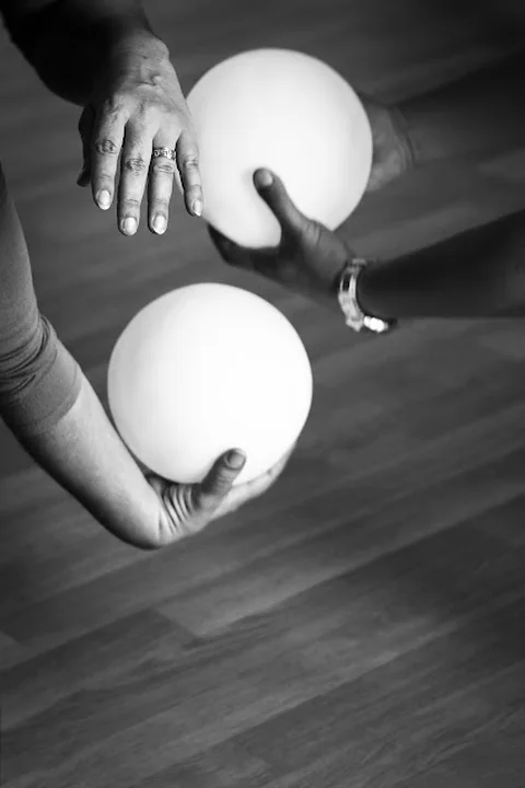 Mains tenant des balles lors d'une séance de danse-thérapie