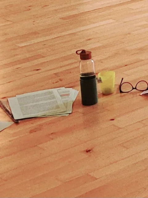 Cahier, notes et objets posés sur le sol d'un studio, espace de réflexion clinique en supervision